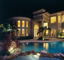 Night view of pool and grand home